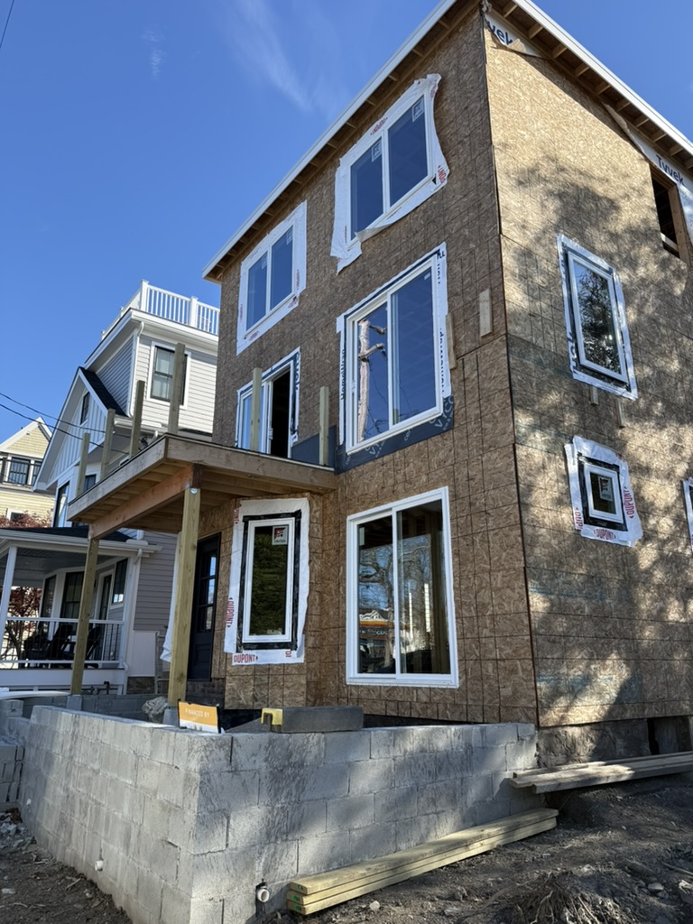 Front view of the multi-story Newport renovation with balcony framing