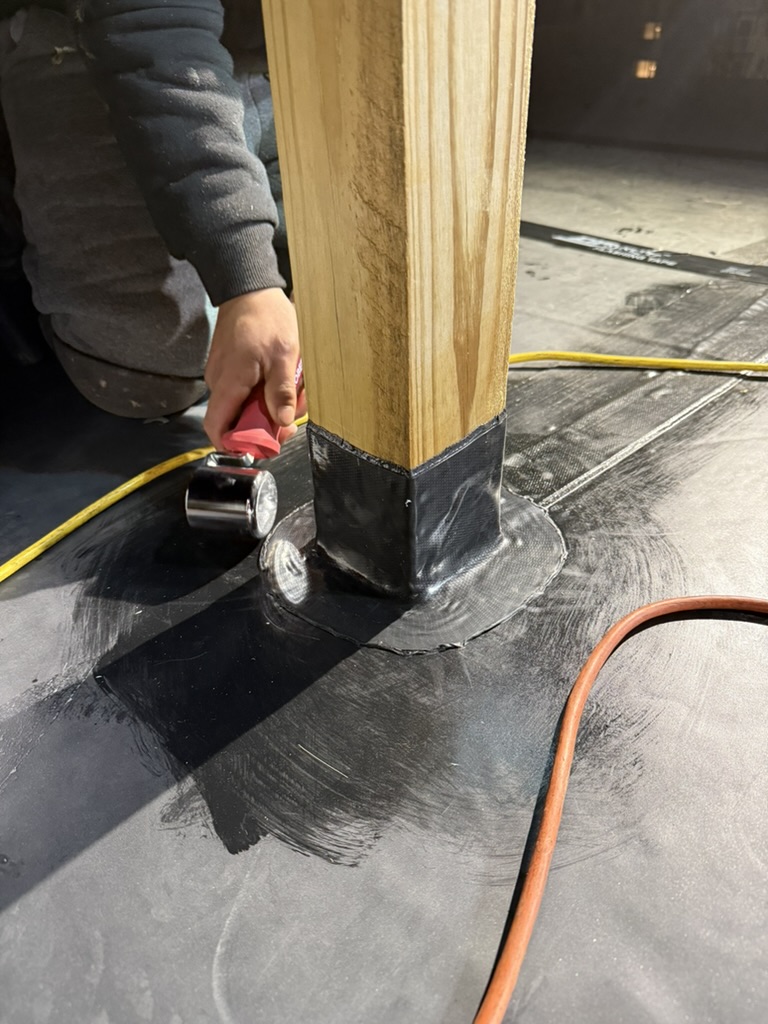 Close-up of EPDM membrane carefully wrapped around a deck post base