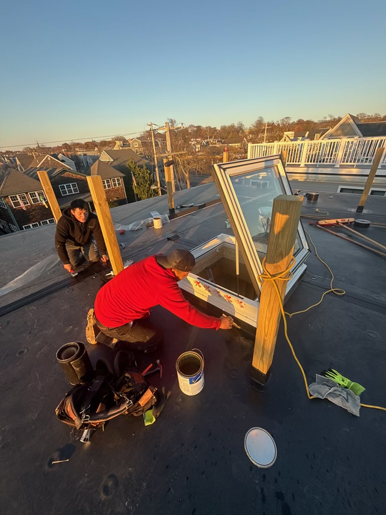 Crew installing the roof access skylight at sunset