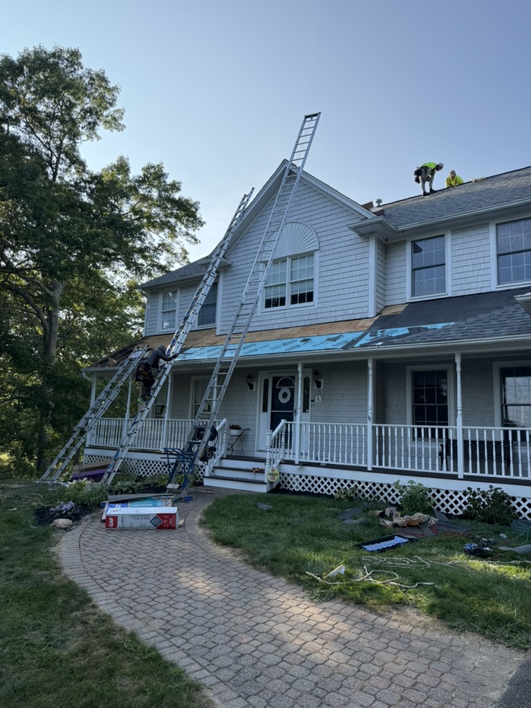 Colonial home roofing project with crew on ladders